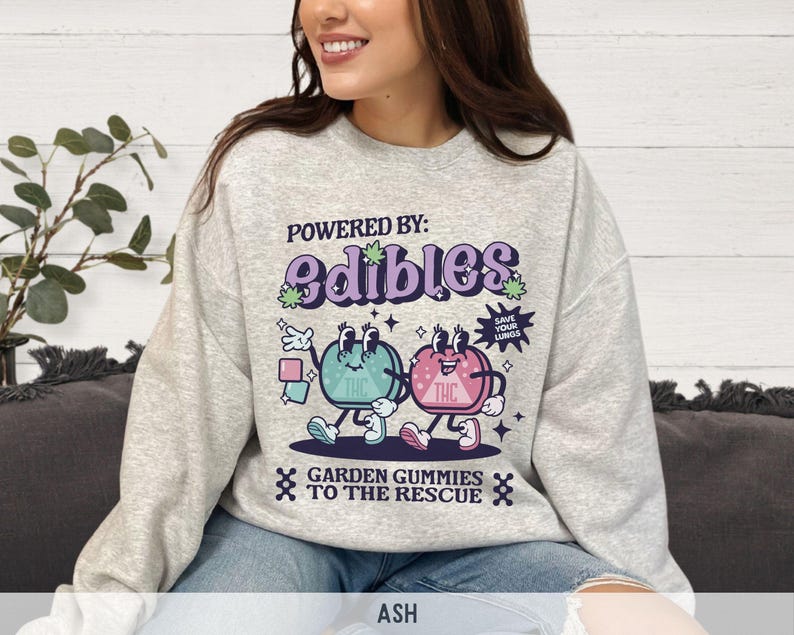 May include: Gray sweatshirt with a graphic of two cartoon gummies with the text "Powered by: edibles" and "Garden gummies to the rescue".