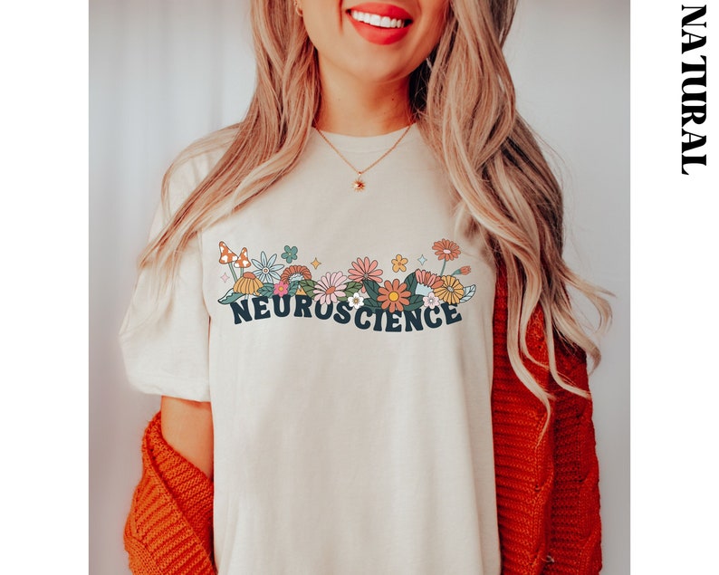 May include: A white t-shirt featuring a colourful floral design and the text "NEUROSCIENCE" in blue lettering.