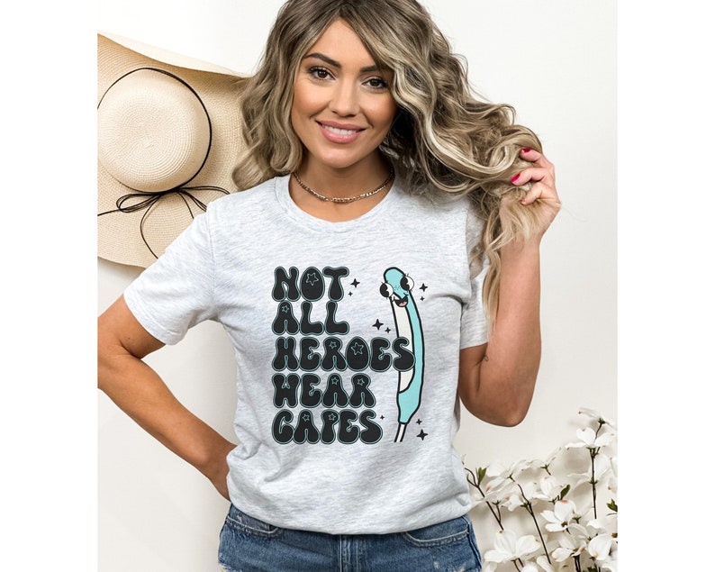 May include: A gray t-shirt with a graphic of a stethoscope and the text "Not all heroes wear capes".
