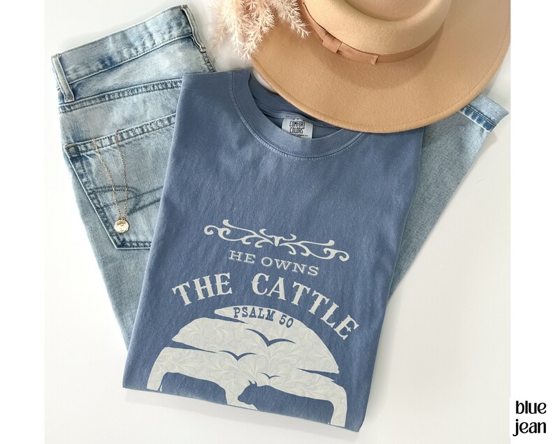 May include: A blue t-shirt with a white graphic that says "He owns the cattle Psalm 50".