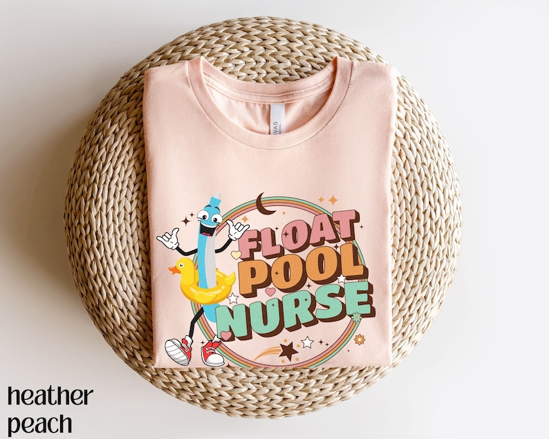 May include: A peach coloured t-shirt with a graphic of a cartoon pencil wearing a yellow rubber ducky float and the text "FLOAT POOL NURSE" in a retro font.