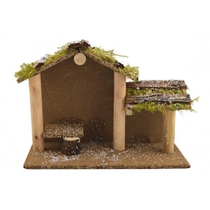 May include: A wooden nativity stable with a moss roof and a snowy base. The stable has a small wooden bench inside and a wooden log for a table.