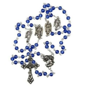 May include: A blue crystal rosary with silver angel and cross charms. The rosary beads are faceted and have a light blue color.
