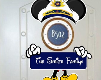 May include: A Mickey Mouse-themed door decoration featuring a captain's hat, a porthole with the number 8502, and a sign that reads "The Smith Family." The design includes Mickey's iconic ears, hands, and yellow shoes, all set against a white door.