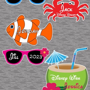 May include: Four Disney-themed photo booth props featuring a red crab with the text "Jack Disney Dream", a blue and black pair of sunglasses with the text "Jack 2023", a pink and black pair of sunglasses with the text "Jill 2023", and a cartoon clownfish with the text "Jordan".