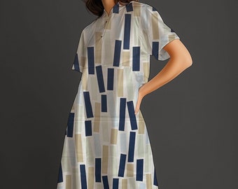 May include: A white dress with a geometric pattern of blue and beige rectangles. The dress has a collar and short sleeves.