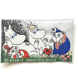 May include: A rectangular patch featuring a colorful illustration of Moomin characters. The image shows two white, hippo-like creatures, a small red-dressed character, and a blue-clad cat-like figure. The patch has a green border and the text "MOOMIN CHARACTERS/BULLS".