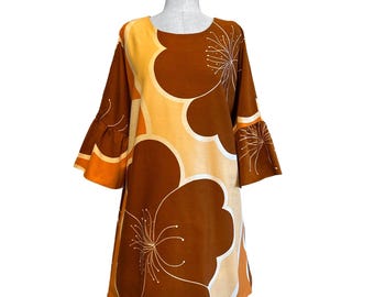 May include: A brown and orange dress with a floral print. The dress has a round neckline and 3/4 sleeves with bell bottoms.