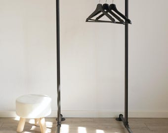 Black metal clothes rack in industrial style, freestanding clothes rail made of pipe