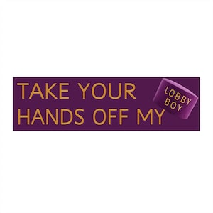 Peut inclure: Un panneau rectangulaire violet avec des lettres dorées qui dit "TAKE YOUR HANDS OFF MY". Un petit objet cylindrique violet avec les mots "LOBBY BOY" est dans le coin supérieur droit. Le fond est blanc.