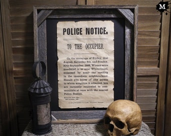 May include: A framed vintage-style police notice with the text "POLICE NOTICE. TO THE OCCUPIER." and a description of murders in Whitechapel in 1888. The notice is on a dark background and is framed in a rustic wood frame.