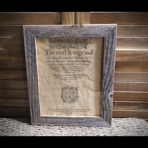 May include: A framed antique document with the text "The most strange and admirable discouerie of the three Witches of Warboys, arraigned, conuicled, and executed at the last Assifes at Hunting-too, for the bewitching of the hue daughters of Robert the blacksmith, Elizabeth, and Agnes, his daughters, and for the bewitching to death of the Lady Cromwell, the like hath never been heard of in this age."