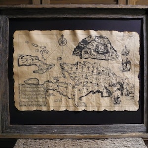 May include: A framed black and white map of an island with a compass rose and text. The map is on aged paper with a distressed look and is framed in a rustic wood frame.