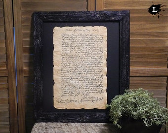 Könnte beinhalten: Ein gerahmtes Dokument mit handschriftlicher schwarzer Tinte auf gealtertem Papier. Das Dokument trägt den Titel "Salem, 18. Mai 1692". Der Rahmen ist aus schwarzem Holz mit einer abgenutzten Oberfläche.