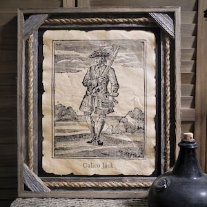 May include: A framed print of a historical illustration of a pirate, Calico Jack, holding a sword. The print is on aged paper with a rope border and a wooden frame.