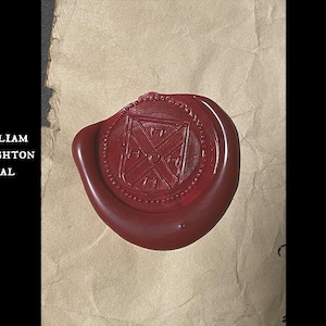 Op de afbeelding: Een dieprode waszegel met een gedetailleerd wapenontwerp, tegen een achtergrond van getextureerd, verouderd papier. De zegel is cirkelvormig met een ingewikkeld patroon. Tekst links luidt "William Stoughton Seal".