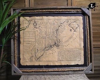Puede incluir: Un mapa antiguo enmarcado de Nueva Inglaterra, Nueva York, Nueva Jersey y Pensilvania. El mapa está impreso en papel envejecido y presenta una representación detallada de la geografía de la región. El marco es de madera rústica con un borde de cuerda.