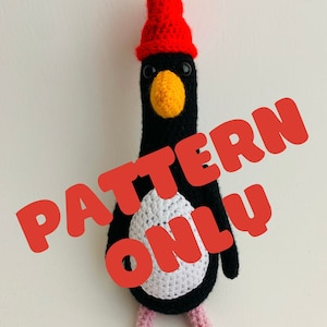Puede incluir: Patrón de amigurumi de pingüino de crochet, con un pingüino blanco y negro que lleva un gorro rojo. El patrón está a la venta, no el producto terminado. El texto "PATTERN ONLY" está superpuesto a la imagen.