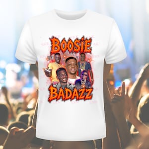 Op de afbeelding: Wit T-shirt met een grafisch ontwerp met de tekst "BOOSIE BADAZZ" in een vlammende lettertype. Het ontwerp bevat een collage van afbeeldingen van de rapper. Het shirt heeft een klassieke ronde hals.
