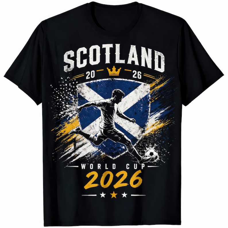 May include: Black t-shirt featuring a soccer player kicking a ball, with the text "SCOTLAND" above a shield with the Scottish flag. The shirt also displays "WORLD CUP 2026" and the years "20-26".