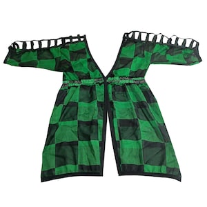 May include: A green and black checked sheer top with a V-neck and cut-out shoulder straps.