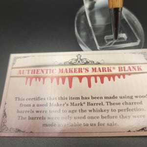 May include: A card with the text "AUTHENTIC MAKER'S MARK BLANK" and a decorative border. The card states the item is made from wood from a used Maker's Mark Barrel.