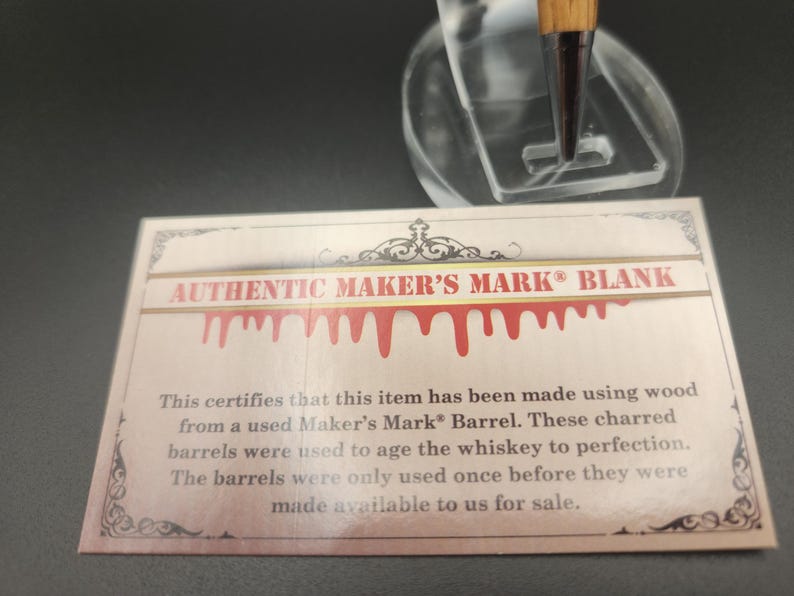 May include: A card with the text "AUTHENTIC MAKER'S MARK BLANK" and a decorative border. The card states the item is made from wood from a used Maker's Mark Barrel.