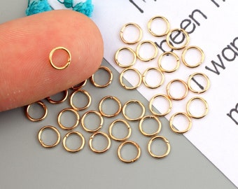 May include: A close-up of a pile of gold jump rings. The rings are small and round, and they are perfect for jewelry making.