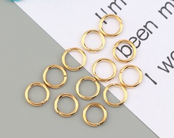 May include: A collection of 12 gold jump rings, perfect for jewelry making or crafting projects.