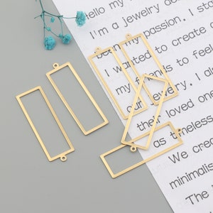 Peut inclure: Un ensemble de cinq cadres rectangulaires en métal doré avec un trou en haut pour la suspension. Les cadres sont de tailles différentes et sont disposés sur une surface blanche avec du texte.