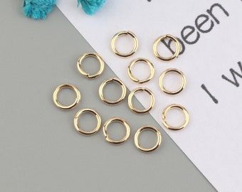 May include: A collection of 12 gold jump rings, perfect for jewelry making or crafting projects.