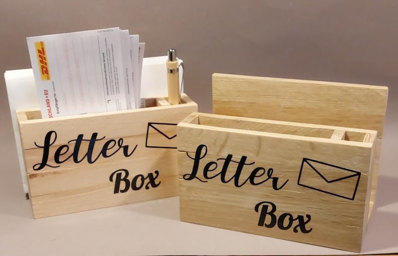 Könnte beinhalten: Zwei hölzerne Briefkästen mit dem Text "Letter Box" und einer Briefumschlaggrafik. Die Kästen sind aus Naturholz gefertigt und haben einen rustikalen Look.
