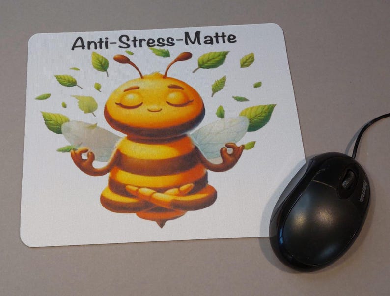 Könnte beinhalten: Ein weißes Mauspad mit einer meditierenden Cartoon-Biene mit dem aufgedruckten Text "Anti-Stress-Matte".