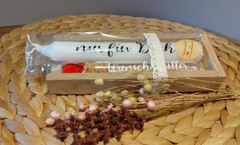 Könnte beinhalten: Eine Holzkiste mit einer weißen Kerze, einem roten Herzen und einem kleinen Glasfläschchen mit einem Korkstopfen. Die Kerze trägt den Text "nur für Dich". Die Kiste ist mit einem weißen Spitzenband und einem kleinen braunen Etikett mit dem Text "handmade with love" verziert.
