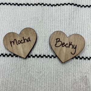 May include: Two wooden heart-shaped tags with the names "Mocha" and "Becky" engraved on them.