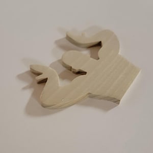 May include: A wooden cutout depicting a flexing arm, with the bicep and forearm clearly defined. The wood is unpainted, displaying a light, natural tone. The cutout is set against a plain white backdrop, creating a shadow.