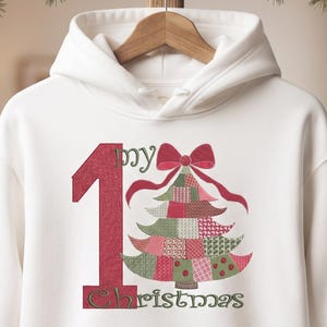 May include: A white hooded sweatshirt featuring a large red number one, the word my in green, and the word Christmas in green. A stylized Christmas tree made of red, green, and white patchwork patterns is topped with a red bow.