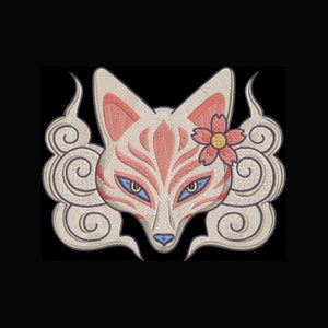 May include: Embroidered fox face with a floral accent. The design features a white fox with pink and red details, blue eyes, and a yellow-centered pink flower. The fox is surrounded by cream-coloured cloud-like swirls, all set against a black background.
