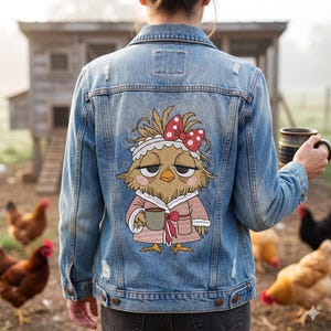 May include: A light blue denim jacket with a distressed design. The back of the jacket features an embroidered cartoon chicken wearing a robe and holding a mug. The chicken has a red bow with white polka dots on its head. Chickens are in the background.