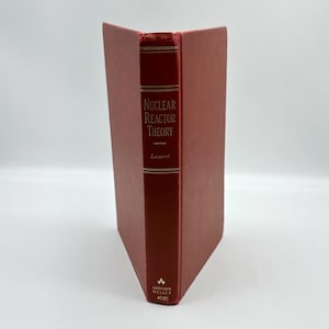 May include: A hardcover book titled "Nuclear Reactor Theory" by Lamarsh. The book has a red cover and spine with gold lettering. The publisher's logo and number 4120 are at the bottom. The book is standing upright.
