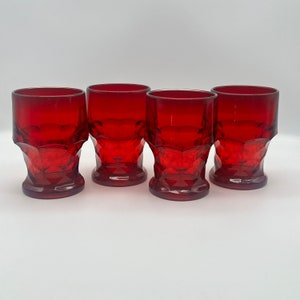 May include: Set of four red glass tumblers with a diamond pattern. The glasses are clear and have a vintage look.