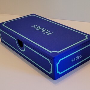 May include: A blue box with a light blue border and the word "Hades" written on the top and bottom of the box.