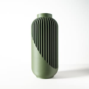 May include: A green ceramic vase with a unique ribbed design. The vase has a cylindrical shape and a smooth, matte finish.