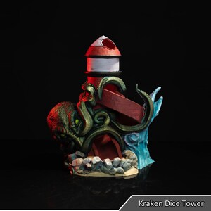Può includere: Una torre da dado kraken verde e rossa con un faro in cima. La torre è realizzata in plastica e ha una superficie testurizzata. Il kraken tiene una rampa rossa che porta al faro. La torre è posizionata su una base con una spiaggia sabbiosa e rocce.