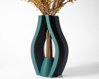 May include: A teal blue ceramic vase with a unique, abstract design. The vase is made of multiple curved panels that create a modern and stylish look. The vase is empty, but it is ready to hold flowers or other decorative elements.