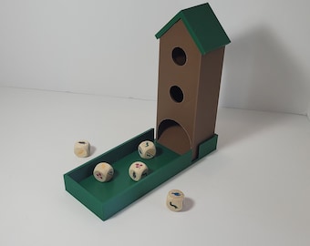 May include: A green wooden dice tower with a brown roof and two openings. Four wooden dice with different colored symbols are scattered around the tower.