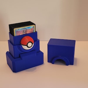 May include: A blue plastic Pokemon card storage box with a Pokeball design. The box is open and has a stack of cards inside. The box is made of 3D printed plastic.