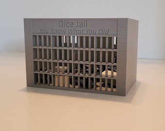 May include: A gray plastic dice jail with metal bars and the text "Dice Jail You Know What You Did".