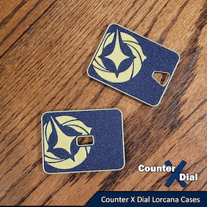 May include: Two blue and gold square-shaped Lorcana card sleeves with a star-shaped design. Counter X Dial Lorcana Cases.