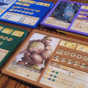 May include: A collection of board game components, including cards and tokens, in various colors such as blue, green, purple, and brown. The cards feature illustrations and text, with a focus on game mechanics and special abilities.